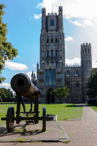 Canon outside Ely Cathedral Seen in front of the West Tower of Ely Cathedral, the Russian Cannon captured during the Crimean War which was presented to the people of Ely by Queen Victoria in 1860 to mark the creation of the Ely Rifle Volunteers. City of Ely, Cambridgeshire, UK, taken on 29th Aug 2017. ely england stock pictures, royalty-free photos & images
