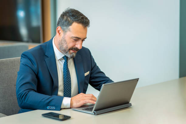 istock A suit-wearing, bearded and handsome employee who trades on his computer 1186956219