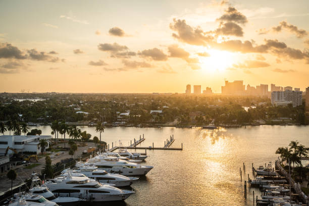 luxusyacht auf einem kanal geparkt mit der sonne, die in fort lauderdale untergeht. hafen von fort lauderdale mit sonnenuntergang am yachthafen - southern usa house south mansion stock-fotos und bilder