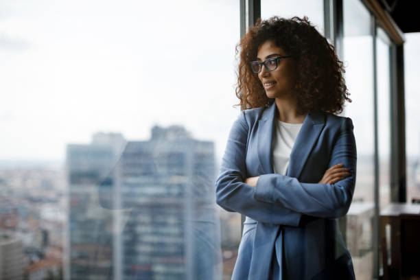 istock Smiling thoughtful businesswoman looking through window 1186957519