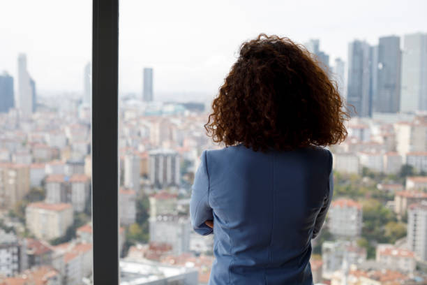 Thoughtful businesswoman looking through window