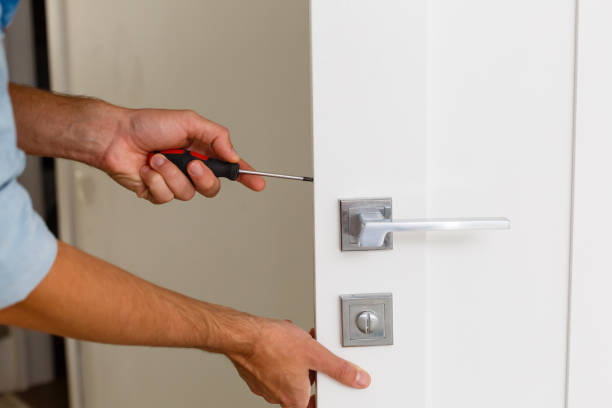 istock Master with screwdriver installs door hinges. 1186958967