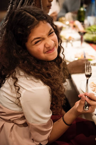 istock Cute girl making a funny face during Thanksgiving dinner. 1186962039