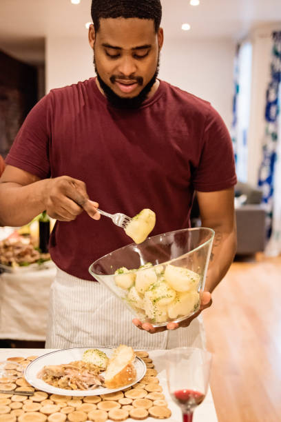 istock African-american man serving himself Thanksgiving dinner. 1186962076