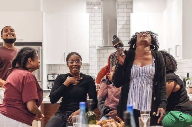 istock Multi-generation ethnic family having Thanksgiving dinner, doing karaoke 1186962153