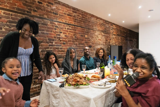 istock Multi-generation ethnic family having Thanksgiving dinner, doing karaoke 1186962161