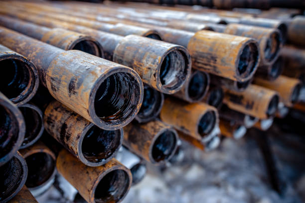 Oil Drill pipe. Rusty drill pipes were drilled in the well section. Downhole drilling rig. Laying the pipe on the deck. View of the shell of drill pipes laid in courtyard of the oil and gas warehouse. tubo de perforación de aceite. las tuberías de perforación oxidadas se perforaron en la sección del pozo. plataforma de perforación. colocando la tubería en la cubierta. vista de la cáscara de las tuberías de perforación colocadas en el patio del