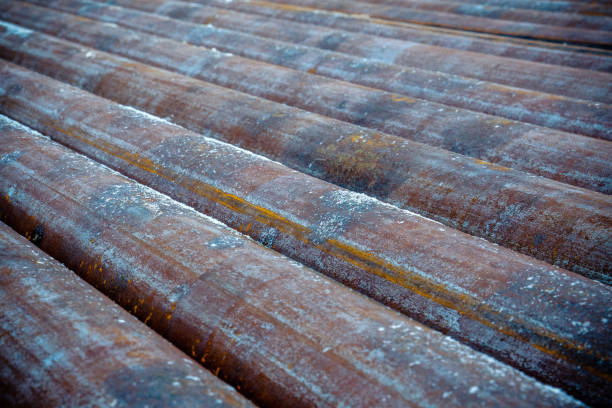 Oil Drill pipe. Rusty drill pipes were drilled in the well section. Downhole drilling rig. Laying the pipe on the deck. View of the shell of drill pipes laid in courtyard of the oil and gas warehouse tubo de perforación de aceite. las tuberías de perforación oxidadas se perforaron en la sección del pozo. plataforma de perforación. colocando la tubería en la cubierta. vista de la cáscara de las tuberías de perforación colocadas en el patio del