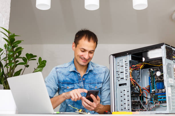 homme utilisant l'ordinateur portatif pour vérifier des serveurs dans le centre de données - l'homme et les nouvelles technologies photos et images de collection