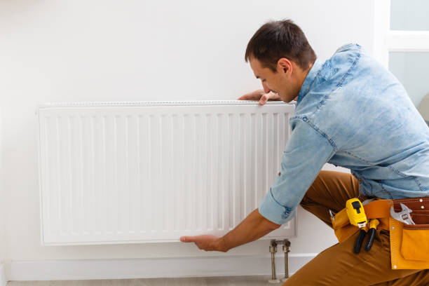 man fixing a heating radiator - water heater installing boiler radiator imagens e fotografias de stock