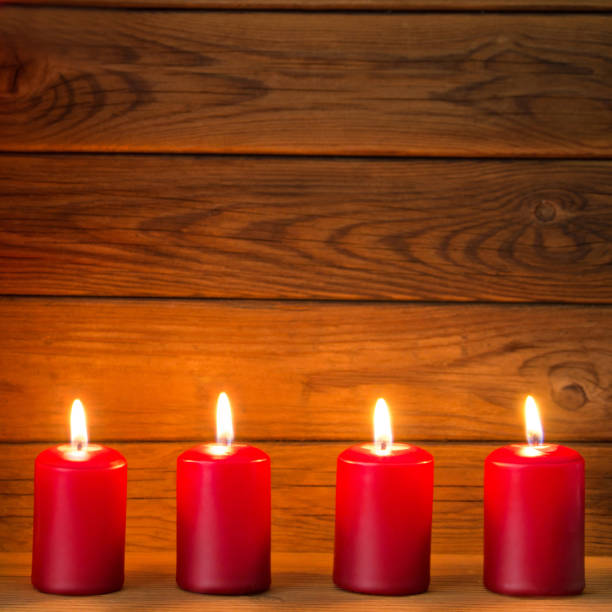 istock Four red candles and wooden background 1186964775