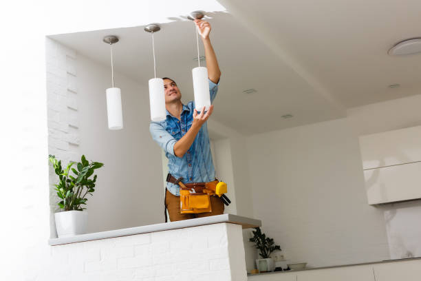 Electrician is installing and connecting a lamp to a ceiling. Electrician is installing and connecting a lamp to a ceiling. installation art stock pictures, royalty-free photos & images