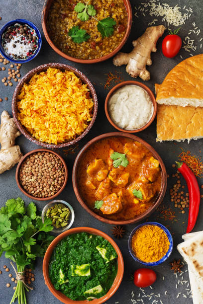 istock Assorted various Indian food on a dark rustic background. Traditional Indian dishes - Chicken tikka masala, palak paneer, saffron rice, lentil soup, pita bread and spices. Top view, flat lay. 1186967151