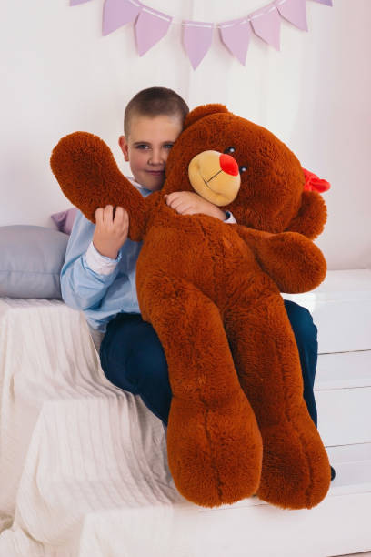istock caucasian boy hugs big brown stuffed bear 1186967912
