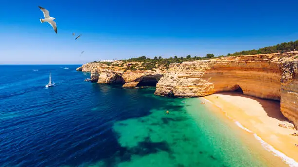 Photo of Corredoura Beach, sighted viewpoint on the trail of the Seven Suspended Valleys (Sete Vales Suspensos). Praia da Corredoura with flying seagulls near Benagil village, Algarve, Portugal.