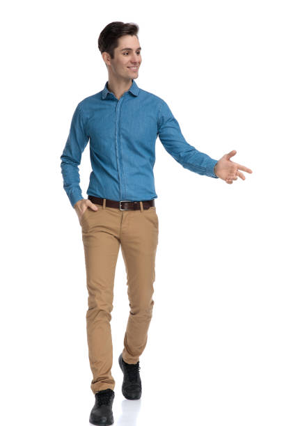 istock happy young man walking and presenting to side 1186973336