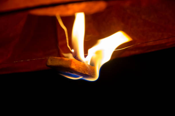 burning fire in orange sky lantern of wish flying in the dark sky