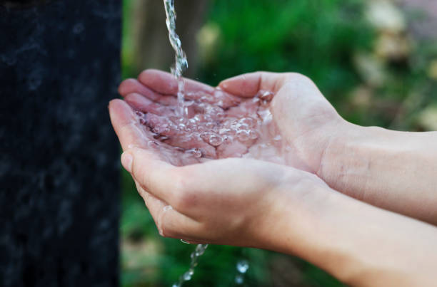 istock Hands with water splash, backlit by the evening sun. 1186974872