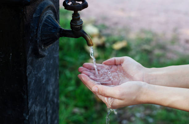 istock Hands with water splash, backlit by the evening sun. 1186974877