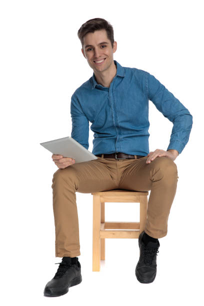istock happy young man smiling and holding tab 1186978594