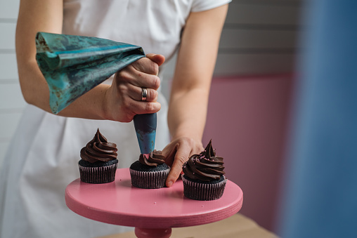 Woman making chocolate cupcakes in her sugar workshop