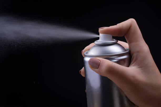 istock Female hand holds an aerosol can on a black background. 1186979952