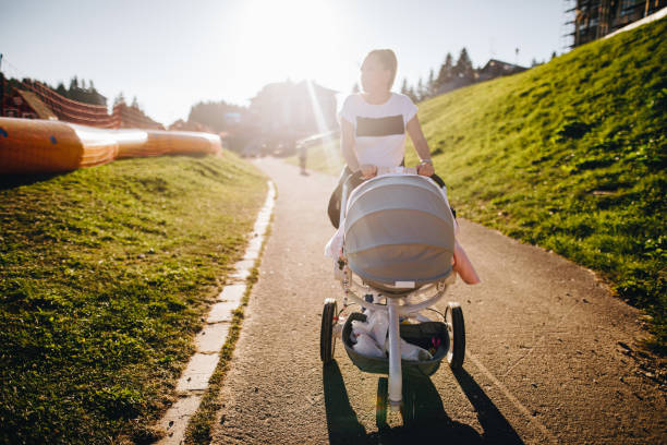 Woman walking with a baby stroller on a mountain vacation