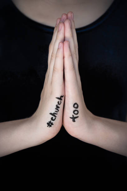istock Woman's hands held in prayer gesture with hashtag church too written on them 1186981444