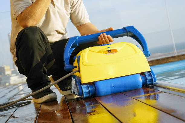 istock Hotel staff worker cleaning the pool. Automatic pool cleaners. 1186981525
