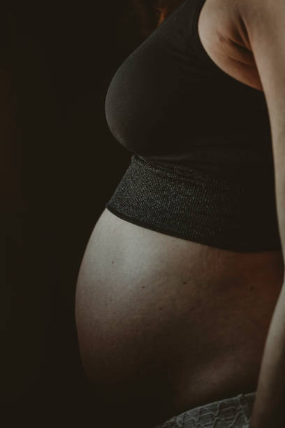 istock Pregnant woman silhouette over black background. Side view 1186982814