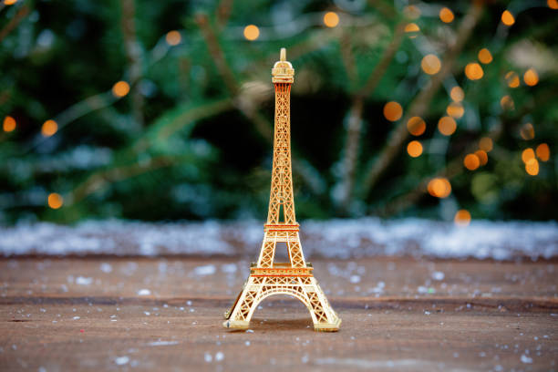 Golden eiffel tower souvenir on table with spruce on background