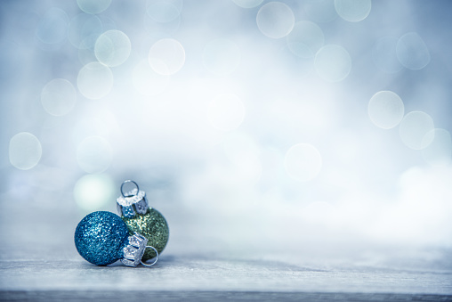 Blue and Green Christmas Baubles against Defocused Background with Copy Space