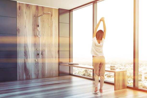 istock Woman in gray bathroom with shower 1186996697