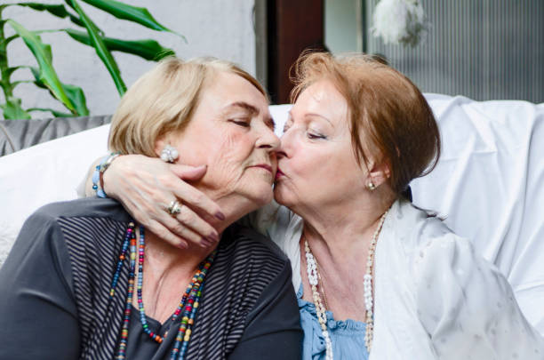 Happy senior female couple embrace and kissing,showing affection.LGBTQI old women Two matured pretty women hug and kiss.Portrait of old woman hugging her elderly sister lesbian stock pictures, royalty-free photos & images