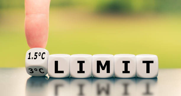 istock Symbol for limiting global warming. Hand turns a dice and changes the expression 