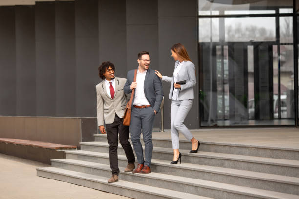 istock Two co-workers congratulating a man on his promotion 1187000790