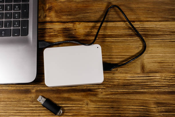 istock External HDD connected to laptop computer and USB flash drive on a wooden desk. Top view. Concept of data storage 1187000800