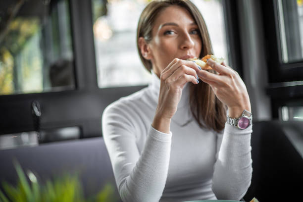 istock Woman eating pizza at restaurant 1187005578
