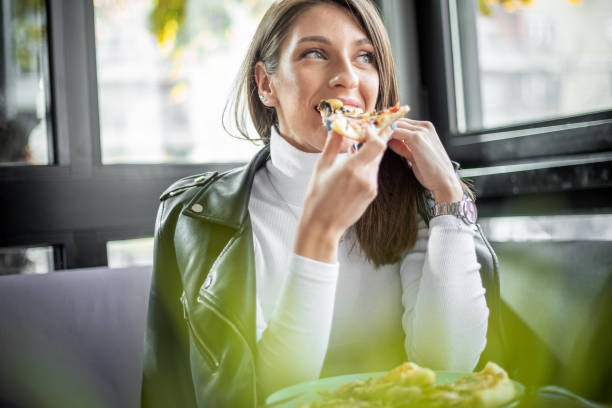 istock Woman eating pizza at restaurant 1187005881