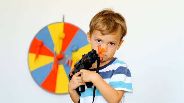 istock Little child boy playing with a toy gun 1187007227