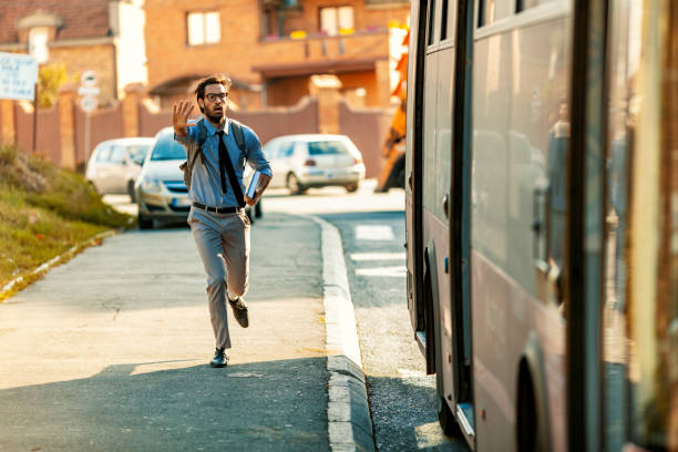 Chasing bus Young casual Businessman with backpacj and book Running To Catch Bus Stop during summer day. bus stock pictures, royalty-free photos & images
