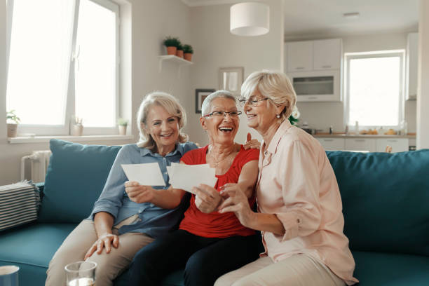 istock Senior Friends Having Fun While Watching Photo Album 1187011852