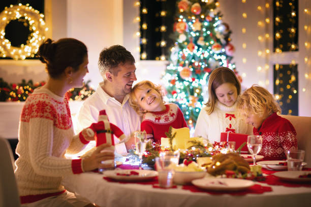 istock Family with kids having Christmas dinner at tree 1187014289