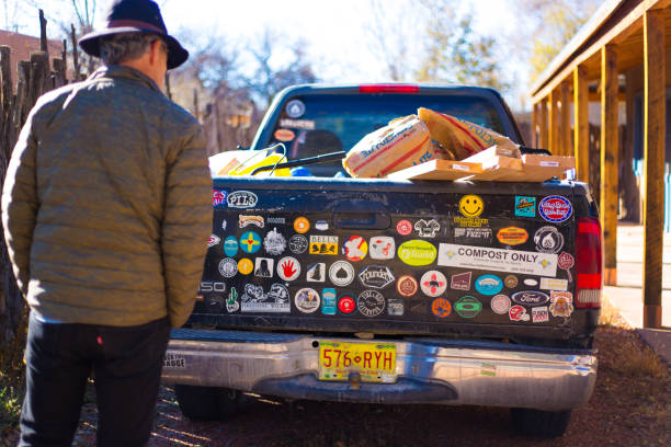 santa fe, nm: homme lisant les autocollants de pare-chocs du pick-up - bumper stickers photos et images de collection