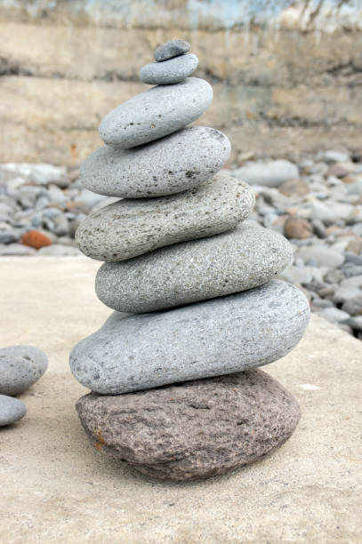 istock Stone cairn tower, poise stones, rock zen sculpture, light grey pebbles 1187015755
