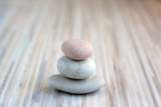 istock Stone cairn on striped grey white background, three stones tower, simple poise stones, simplicity harmony and balance, rock zen 1187015771