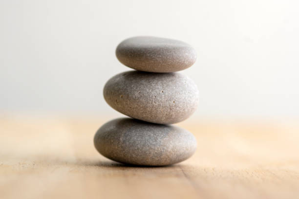 istock Stone cairn on striped grey white background, three stones tower, simple poise stones, simplicity harmony and balance, rock zen 1187015773