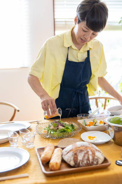 istock Woman pouring dressing to salad on table 1187015793