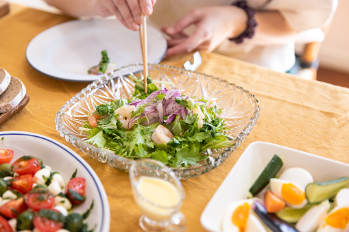 Woman picking up salada at home lunch party