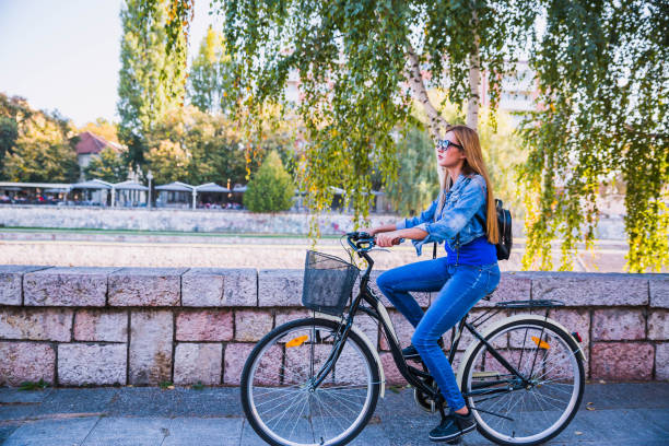 istock Woman in jeans rides in town on a bicycle 1187016708